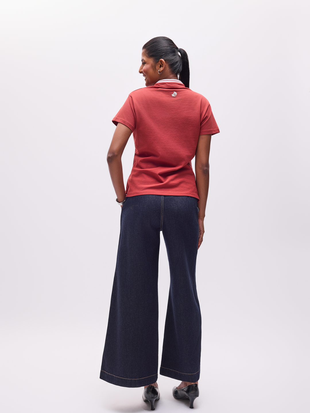 Woman wearing a Chestnut The Groove organic cotton T-shirt with a logo on the reverse.